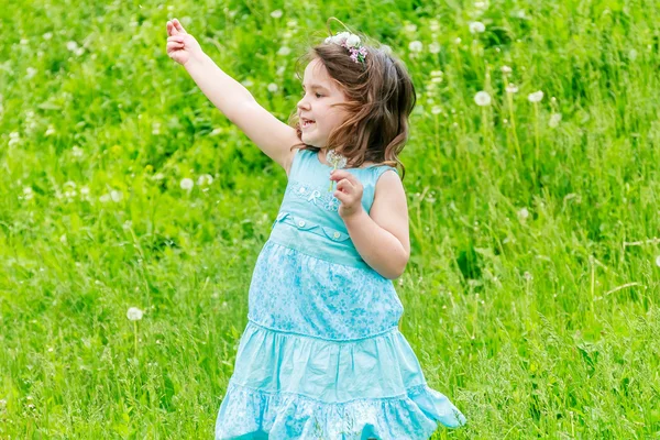 Schöne Kind Mädchen mit Löwenzahnblüte im Frühlingspark. glücklich — Stockfoto