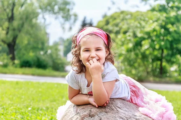 Krásné dítě dívka v parku na jaře. Šťastné dítě baví outdoo — Stock fotografie