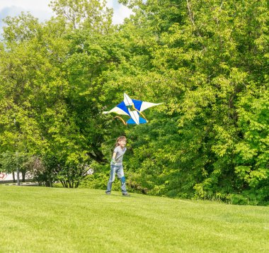 Genç mutlu çocuk çocuk Park parlak uçurtma ile oynarken. Yaz h