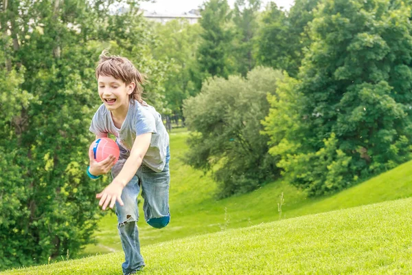 Schattig jong kind jongen opleggen aan het gras in het park. Over oorlog — Stockfoto