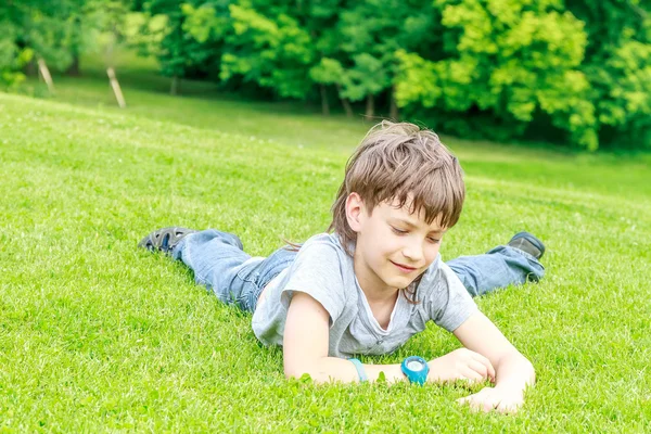 Menino adorável no parque. No dia quente de verão durante — Fotografia de Stock