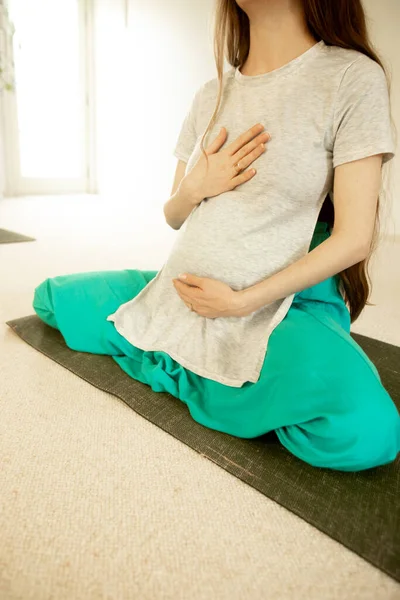 young pregnant woman practicing maternity yoga