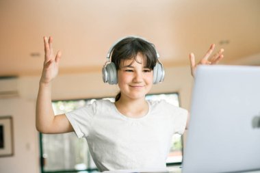 Sevimli beyaz kız çocuğunun portresi çevrimiçi öğrenim yaparken dizüstü bilgisayar, evde eğitim, uzaktan eğitim kullanıyor.