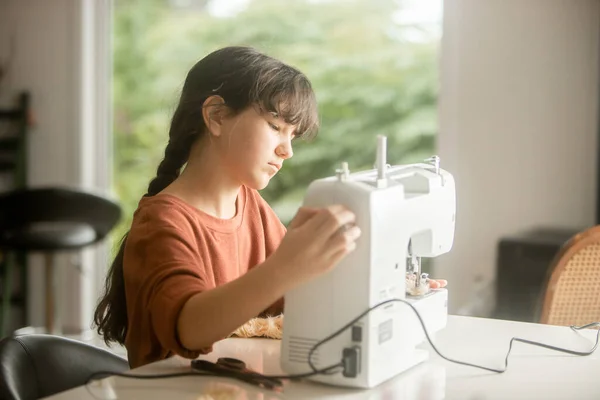 小女孩在家里用缝纫机缝补 — 图库照片