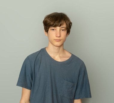 Gri arka planda genç çocuk portresi, ergen çocuk