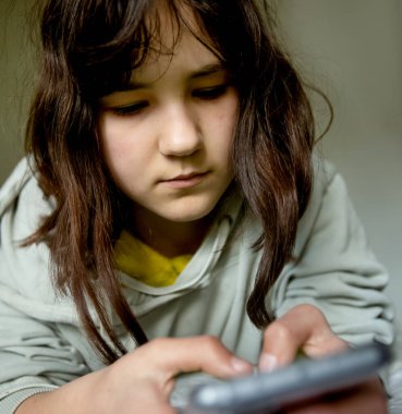 Elinde yeşil ekranlı telefonu olan genç kız, telefonu kullanan ergen kız, modern dijital teknolojiler.