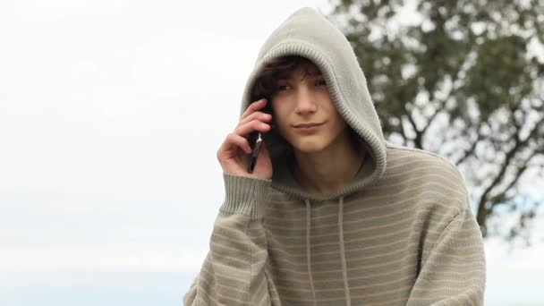 Мальчик-подросток с мобильным телефоном на естественном фоне, мобильная связь, цифровые технологии — стоковое видео