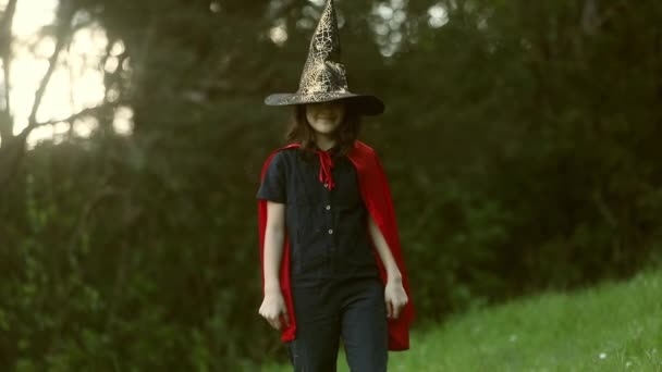 자연의 배경에서 할로윈 파티를 위한 드라큘라 옷을 입은 어린 소녀 — 비디오