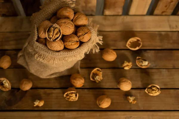 Borsa di tela con noci su sfondo di legno, concetto di raccolta autunnale, cibo sano, ringraziamento e fondo autunno — Foto Stock