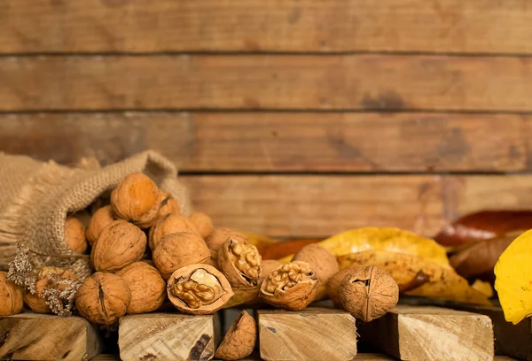 Bolsa de lona con nueces sobre fondo de madera, concepto de cosecha otoñal, comida saludable, acción de gracias y fondo de otoño —  Fotos de Stock