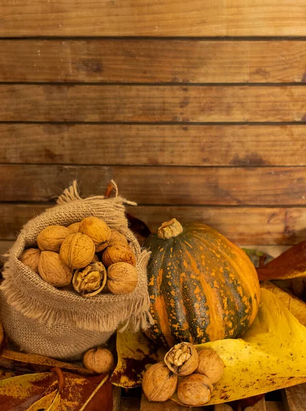 Τσάντα καμβά με καρύδια και κολοκύθα σε ξύλινο φόντο, έννοια συγκομιδή φθινόπωρο, υγιεινά τρόφιμα, Ευχαριστίες και φόντο πτώση — Φωτογραφία Αρχείου