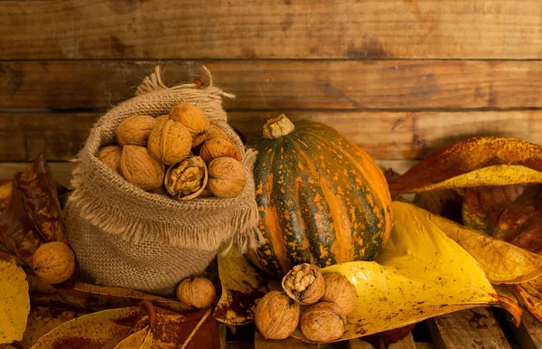 Borsa di tela con noci e zucca su sfondo di legno, concetto di raccolta autunnale, cibo sano, ringraziamento e fondo autunno — Foto Stock