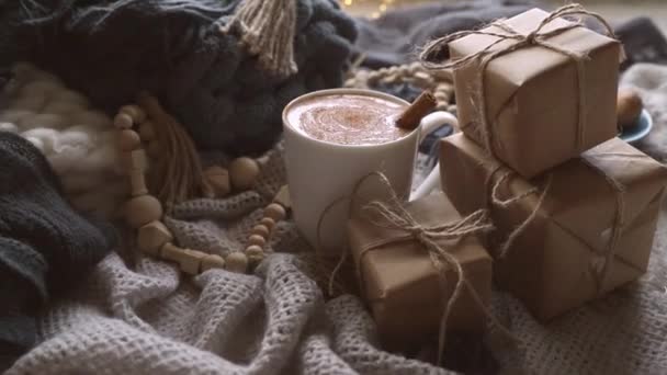 Mañana acogedora estilo escandinavo con algunas mantas de punto, taza de cacao, caja de regalo, invierno y ambiente festivo, ambiente cristmas — Vídeo de stock