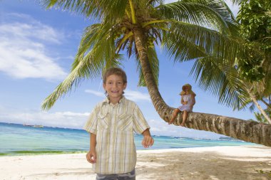 iki genç mutlu çocuk - erkek ve kız - tropikal plaj backgrou üzerinde