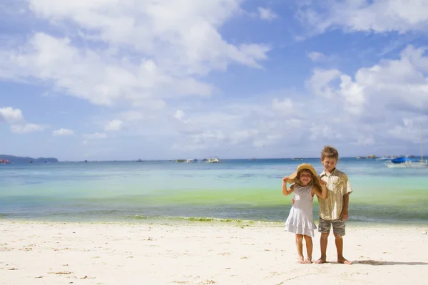Two children - boy and girl - on tropical beach and sea backgrou — Stock Photo, Image