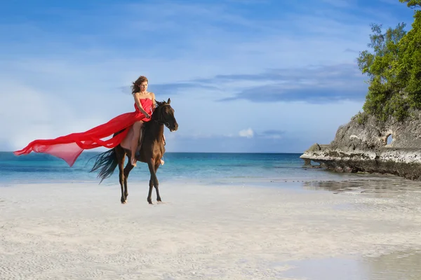 Unga vackra kvinnan Rider en häst på tropical beach — Stockfoto