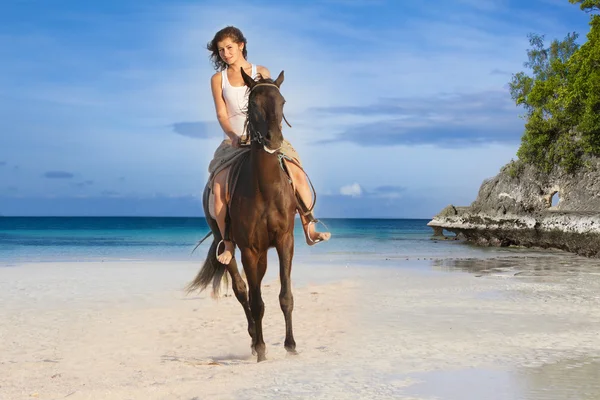 Молодая красивая женщина верхом на лошади на тропическом пляже — стоковое фото