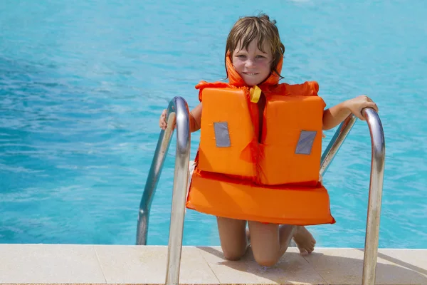 Young happy smiling child girl in inflatable life-jacket swimmin — Stock Photo, Image
