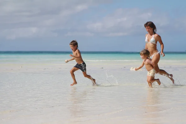 Unga lyckliga familjen - mor och barn - att ha kul på tropic — Stockfoto