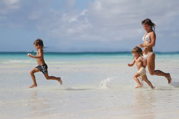 Fiatal, boldog család - anya és a gyermek - szórakozás a tropic — Stock Fotó