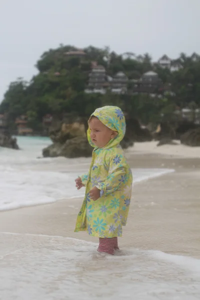 Jonge baby kind onder regen op strand — Stockfoto