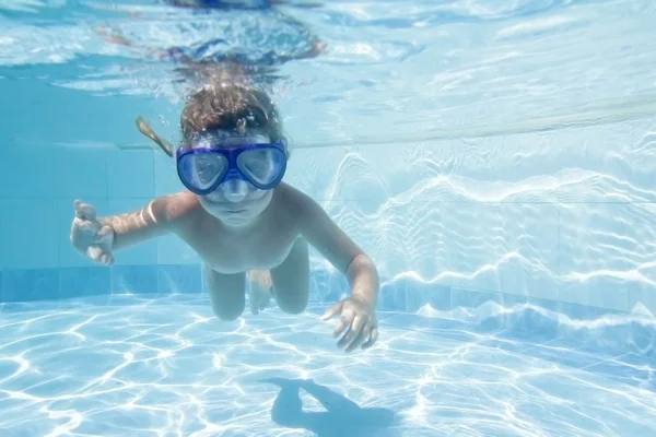 Niño pequeño buceo undwerwater en la máscara en la piscina — Foto de Stock