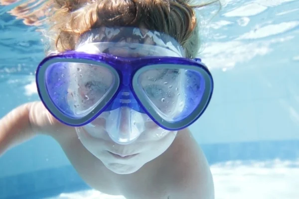 Bambino piccolo immersioni undwerwater in maschera in piscina — Foto Stock