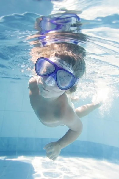 Bambino piccolo immersioni undwerwater in maschera in piscina — Foto Stock