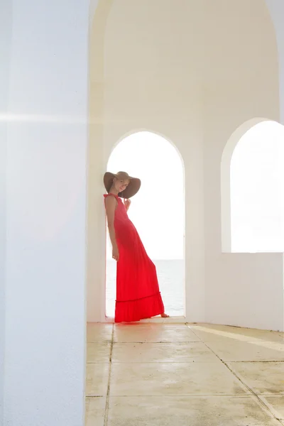 Young beautiful woman in hat standing next to stone wall — Stock Photo, Image