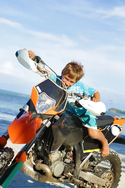 Genç mutlu gülümseyen çocuk üzerinde motosiklet sürme açık portresi 