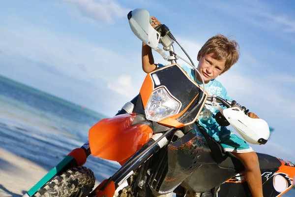 Outdoor portrait of young happy smiling boy riding motorbike on — Stock Photo, Image