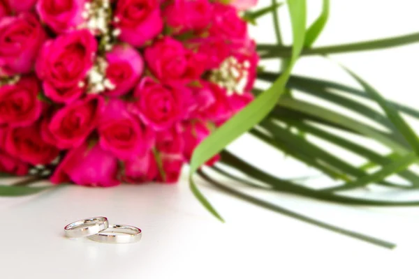 Wedding rings and bridal bouquet of pink roses isolated over whi — Stock Photo, Image