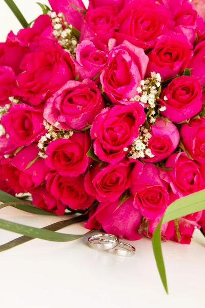 Trauringe und Brautstrauß aus rosafarbenen Rosen vereinzelt über — Stockfoto