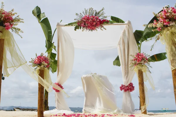 Mooie bruiloft setup en bloemen op tropisch strand achtergrond — Stockfoto