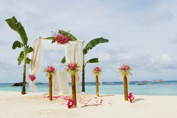 Mooie bruiloft setup en bloemen op tropisch strand achtergrond — Stockfoto