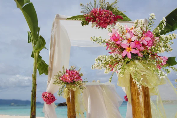 Huwelijksboog en instellen met bloemen op tropisch strand — Stockfoto