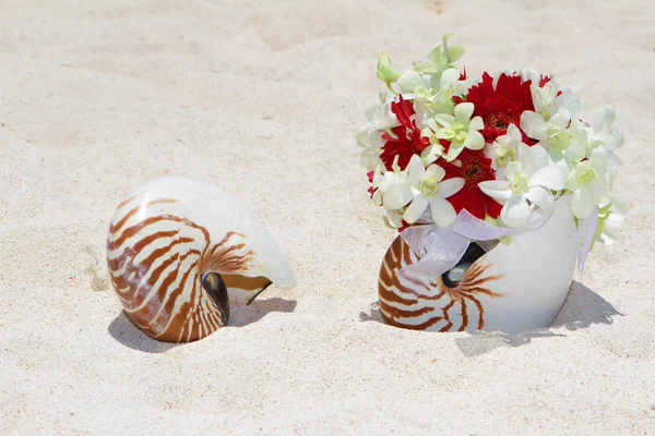 Buquê de noiva com anéis de casamento em uma concha na areia tropical ser — Fotografia de Stock