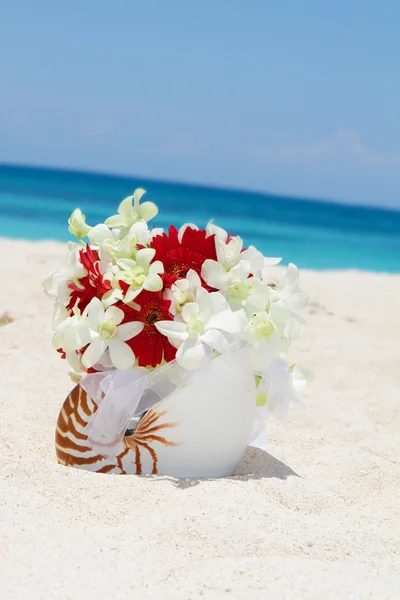 Bouquet da sposa con fedi nuziali in una conchiglia sulla sabbia tropicale essere — Foto Stock