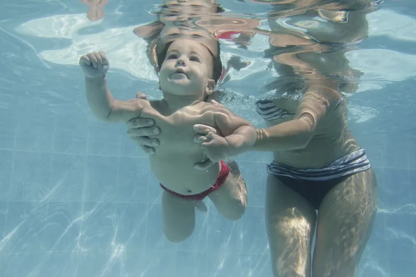 Aranyos baba gyermek anyja víz alatti úszás — Stock Fotó