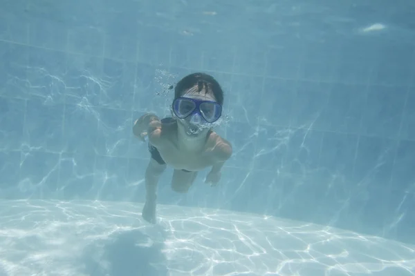 Menino jovem nadando debaixo de água na piscina — Fotografia de Stock
