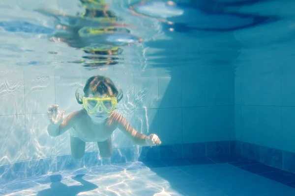 Giovane bambina nuotare sott'acqua in piscina — Foto Stock