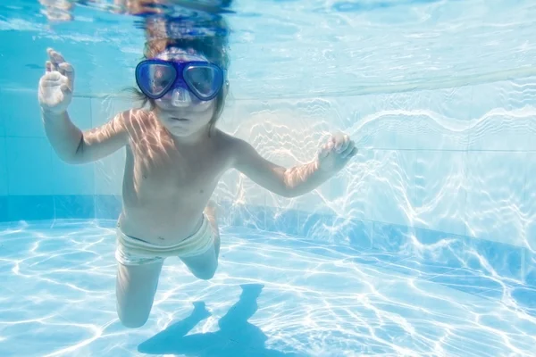 Jong kind onderwater zwemmen in zwembad — Stockfoto