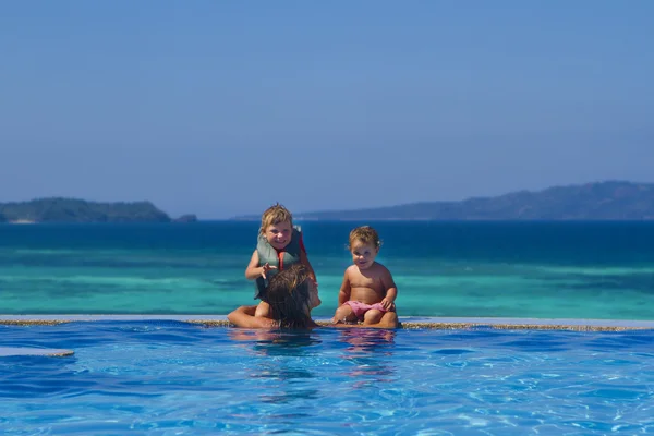 젊은 행복 한 어머니와 수영 포에서 휴가 즐기는 아이 들 — 스톡 사진