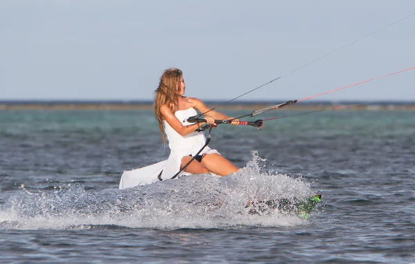 Jeune belle femme en robe de mariée kitesurf sur l'eau retour — Photo