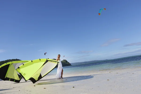 Young beautiful woman in wedding dress kitesurfing on water back — Stock Photo, Image