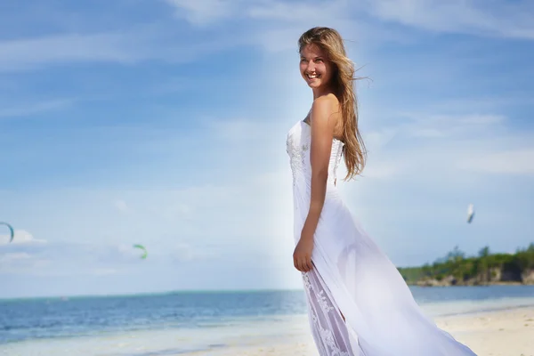 Young beautiful woman in wedding dress on tropical beach and wat — Stock Photo, Image