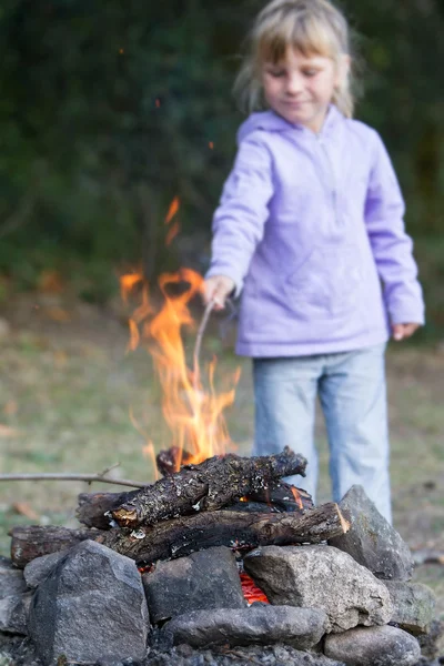 Child girl playing with fire on natural background — Stock Photo, Image