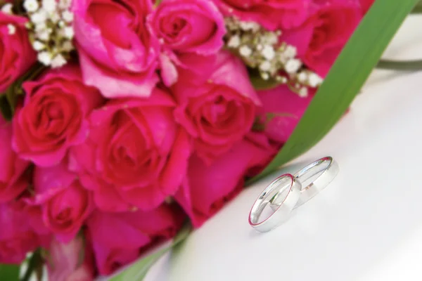 Anillos de boda y ramo de novia sobre blanco —  Fotos de Stock