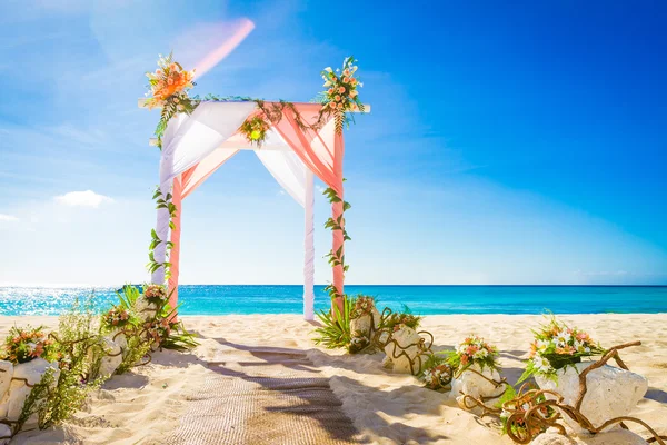 Hochzeitsbogen mit Blumen geschmückt am tropischen Sandstrand, — Stockfoto