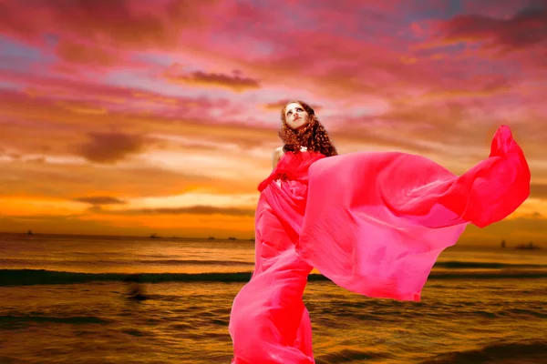 Tropikal deniz günbatımı backgr üzerinde Kırmızı elbiseli genç güzel kadın — Stok fotoğraf